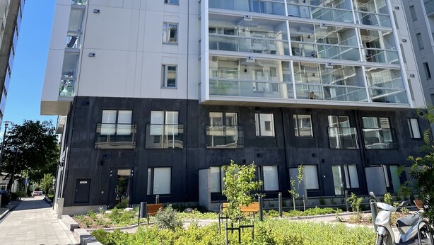 A modern high-rise building with multiple balconies and large windows. - Completely new designer apartment on the ground floor with a spacious patio (Espoo)