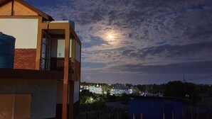 A building with a balcony, a visible window, and a view of the sky with clouds. - Woody Crest Hotel (Trincomalee)