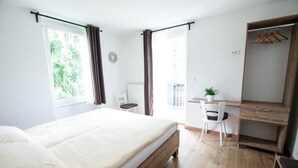 A bedroom with a bed, a desk, a chair, a small table, and a wardrobe. - Hiša Poljana (Prevalje)