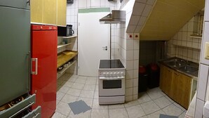 Una cocina compacta equipada con refrigerador, horno, microondas y pileta.