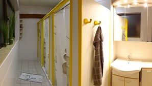 Un baño con un lavamanos blanco, un espejo y una toalla colgada de un gancho.