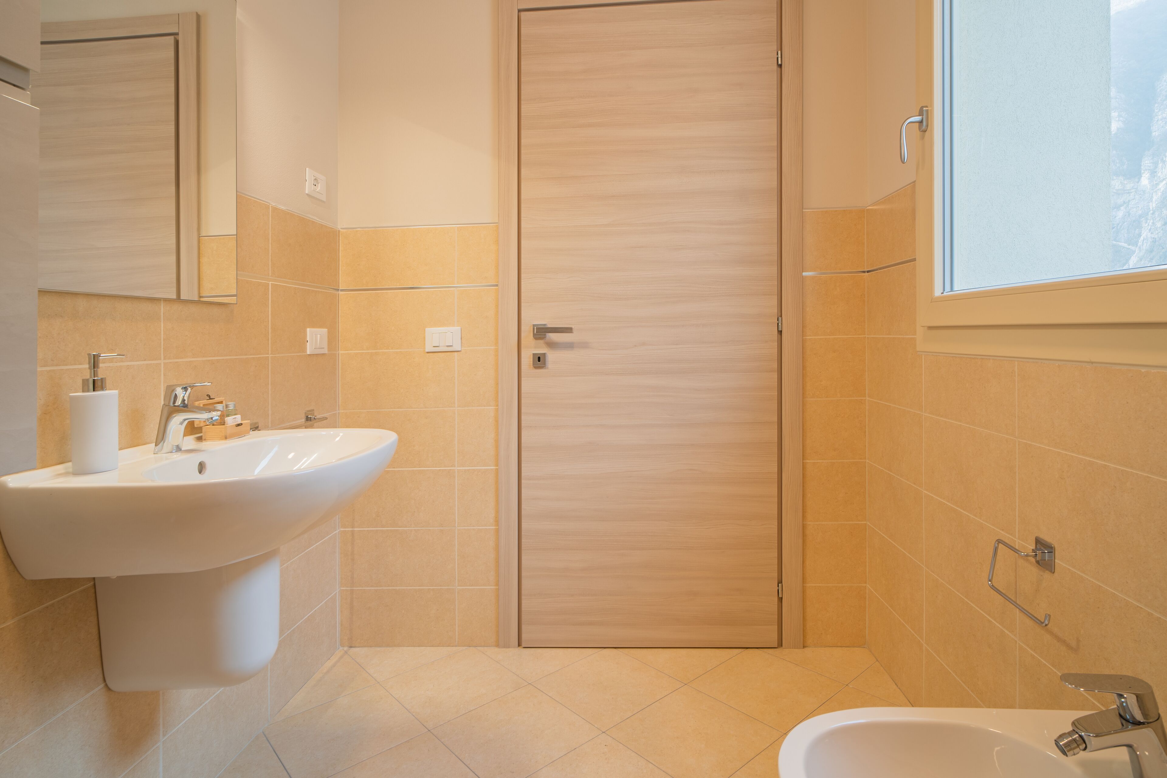 Ein modernes Badezimmer mit Waschbecken, Spiegel und Dusche.