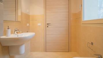 Ein modernes Badezimmer mit Waschbecken, Spiegel und Dusche.