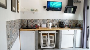 A compact kitchen with a built-in sink, a coffee maker, and a small refrigerator. - Sa Domu de Jana - Studio apartment with garden and panoramic view of Poetto (Quartu Sant'Elena)
