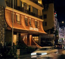 Un hotel con una fachada curva distintiva y un letrero que dice 'LEN HOTEL'.