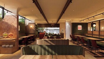 Un ristorante con un'area salotto centrale, un bar e un bancone con esposizione di cibi.