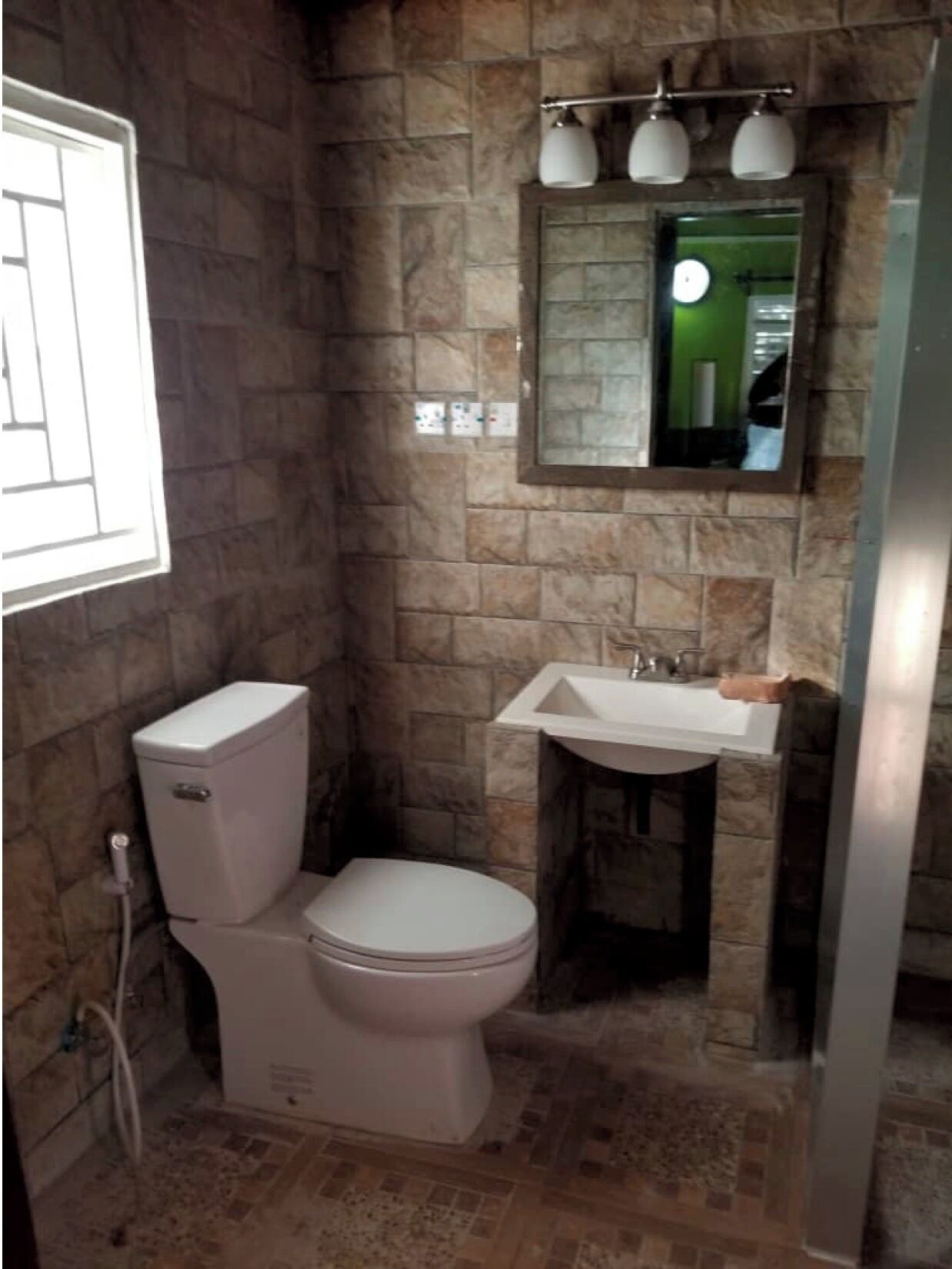 Un baño con inodoro, lavabo y espejo.