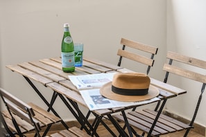 Ett träbord med en flaska S.Pellegrino-vatten, ett glas och en tidning.