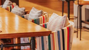 A restaurant with striped upholstered chairs, a wooden table, and a patterned floor.