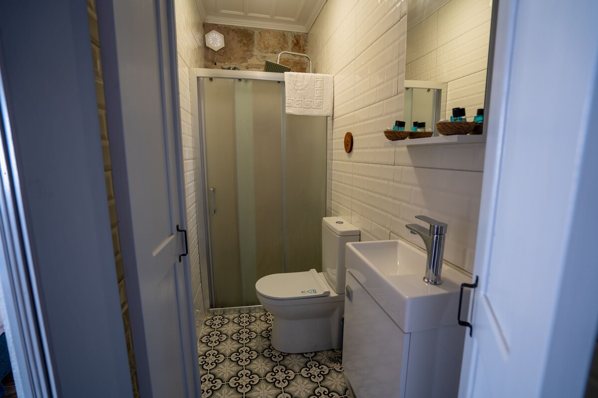 A bathroom with a toilet, sink, and shower.
