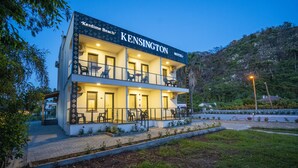 Ein Hotel mit zwei Etagen, mit einem Balkon im oberen Stockwerk, namens 'Kensington Hotel'.