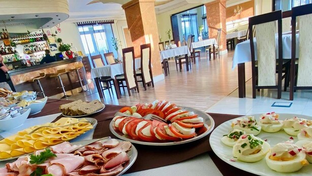 A buffet spread with various food items including sliced tomatoes, cheese, and meat. - Restauracja Hotel Imperial (Jaslo)
