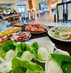 A buffet spread with various food items including sliced tomatoes, cheese, and meat. - Restauracja Hotel Imperial (Jaslo)