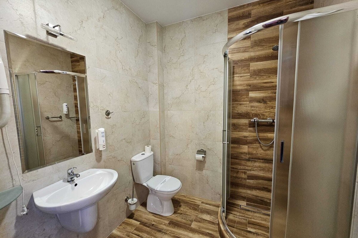 Un baño moderno con ducha, inodoro y lavamanos.