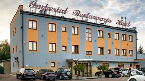 A building with a sign reading "Imperial Restaurant Hotel." It has multiple windows and a parking lot with several cars. - Restauracja Hotel Imperial (Jaslo)