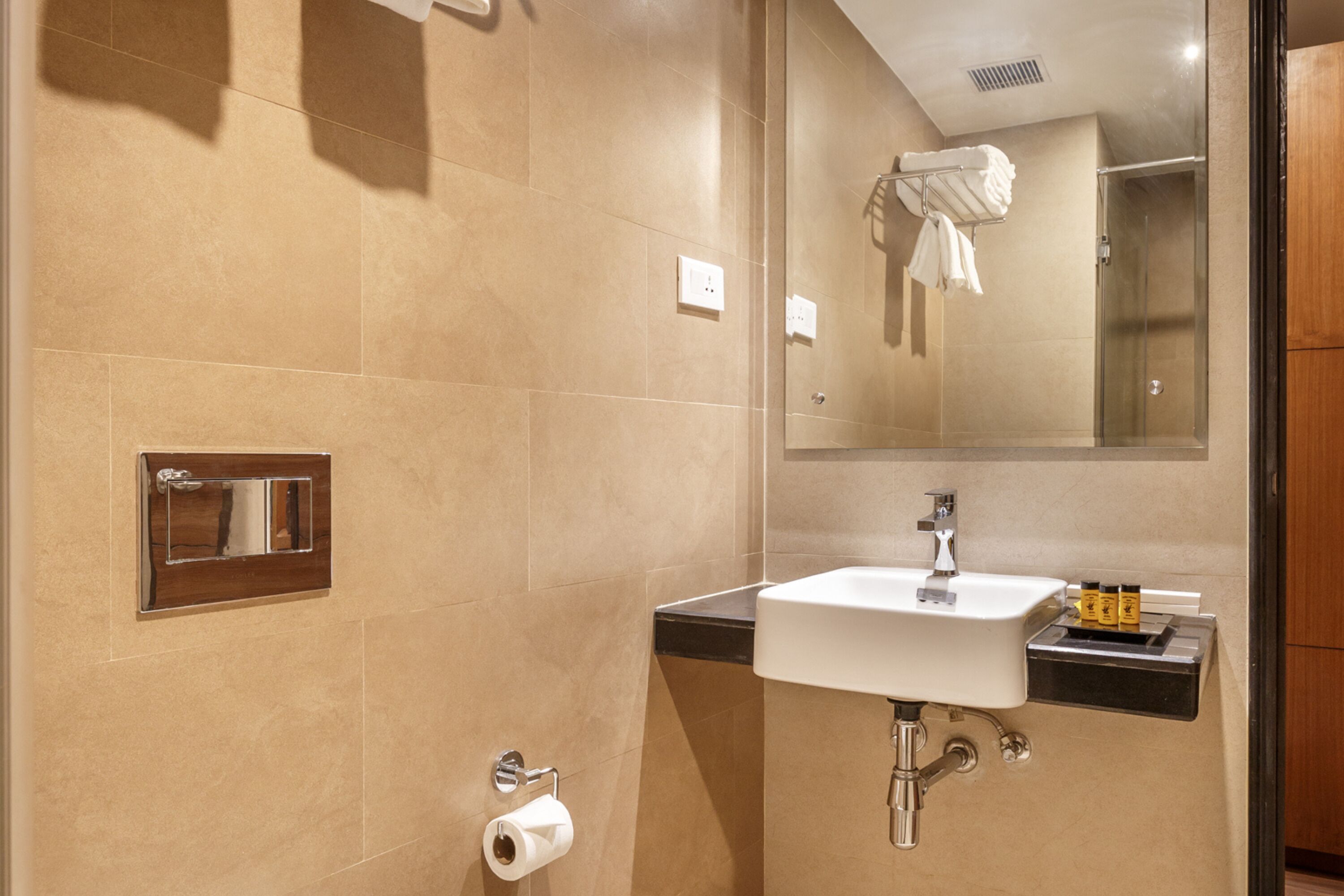 Une salle de bain moderne avec un lavabo, un miroir et un porte-serviettes.