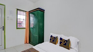 A bedroom with a bed, a green wardrobe, a window with curtains, and a white door. - SPOT ON 91950 Guest House TekNong Syariah (Bangkinang)