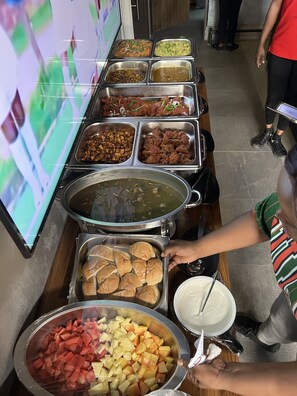 A buffet with various food items including meats, vegetables, and desserts.