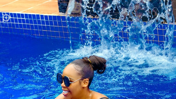 A person in a swimming pool with clear blue water and a tiled edge. - Riviera Lekki Resort (Lekki)