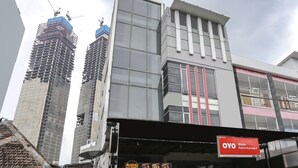 Un bâtiment moderne avec une enseigne indiquant la présence d’un restaurant, le « OYO Wisma Kebon Kacang 9 ».