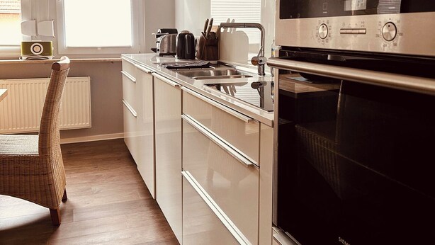 A modern kitchen with a built-in oven, a microwave, and a coffee maker. - Casa Neuenheim (Heidelberg)