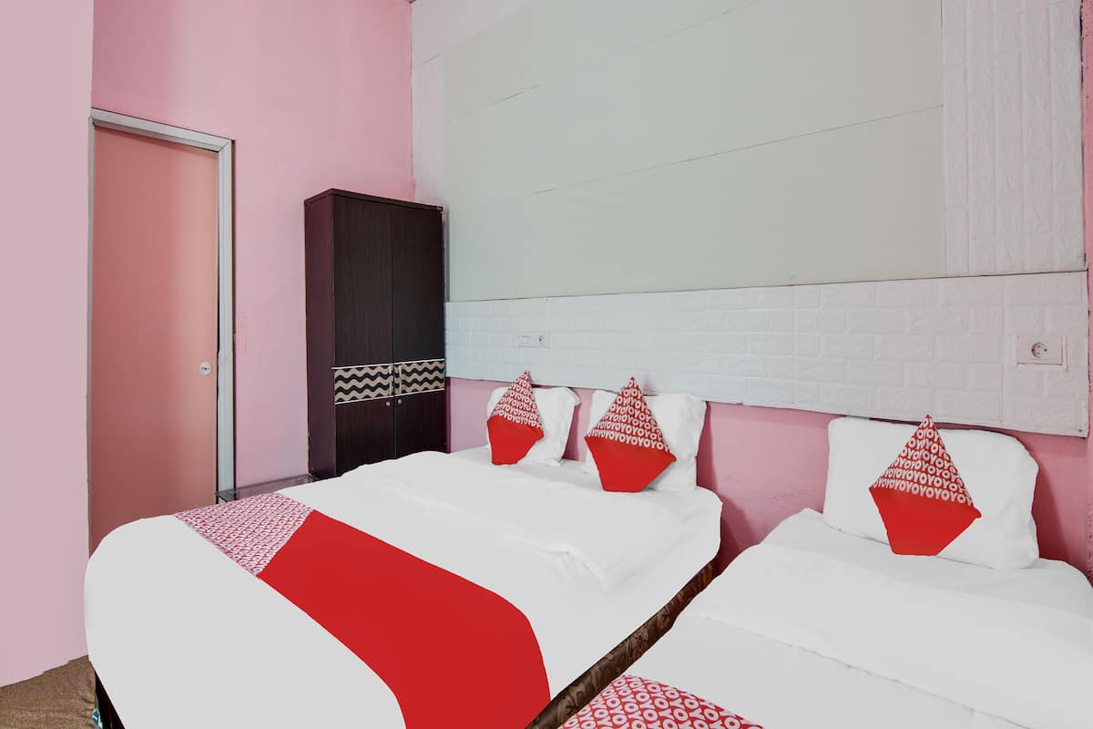 Un dormitorio con dos camas, un armario y una pared de ladrillo blanco con diseño.