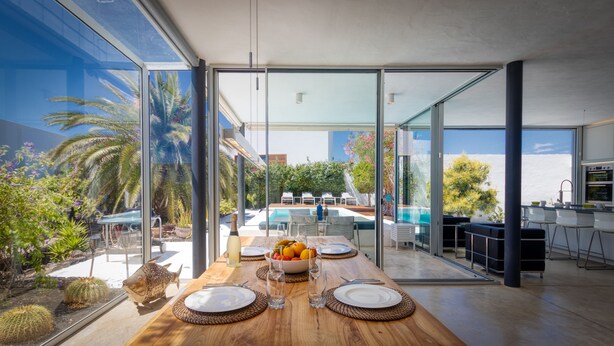 A modern kitchen with a view of a pool and outdoor seating.