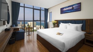 Un hotel moderno con una cama grande, un escritorio y vistas a la ciudad.