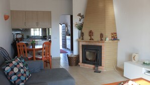 A living room with a sofa, chairs, a wooden coffee table, and a fireplace.