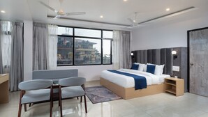 A modern hotel room with a large bed, a desk, and a chair. - Hotel Buddha's Abode- Best Hotel in McleodGanj Main Market (Dharamshala)