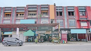 Un edificio de varios pisos con locales comerciales y viviendas.