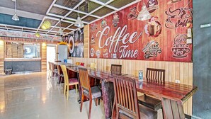 Una cafetería espaciosa con interior de madera, una larga mesa de madera y sillas.