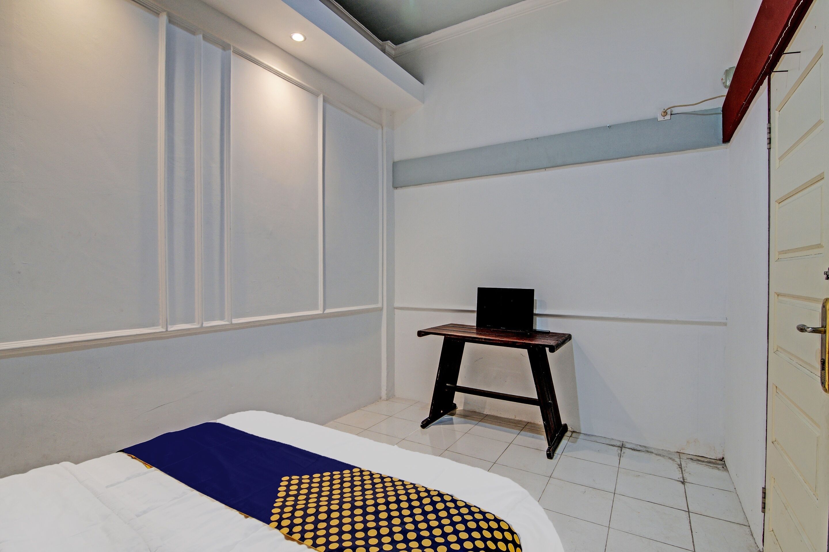 Ein Schlafzimmer mit Bett, Schreibtisch und Fenster.