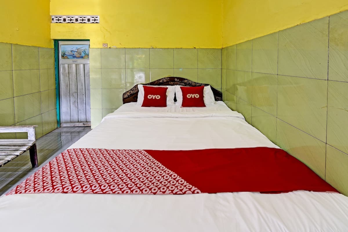Una habitación de hotel con una cama, un banco y una puerta.