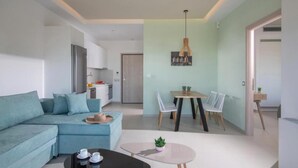 Ein modernes Wohnzimmer mit einer Couch, einem Couchtisch und einem Essbereich mit Stühlen und Tisch.