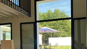 A spacious room with a large sliding glass door leading to an outdoor patio area.