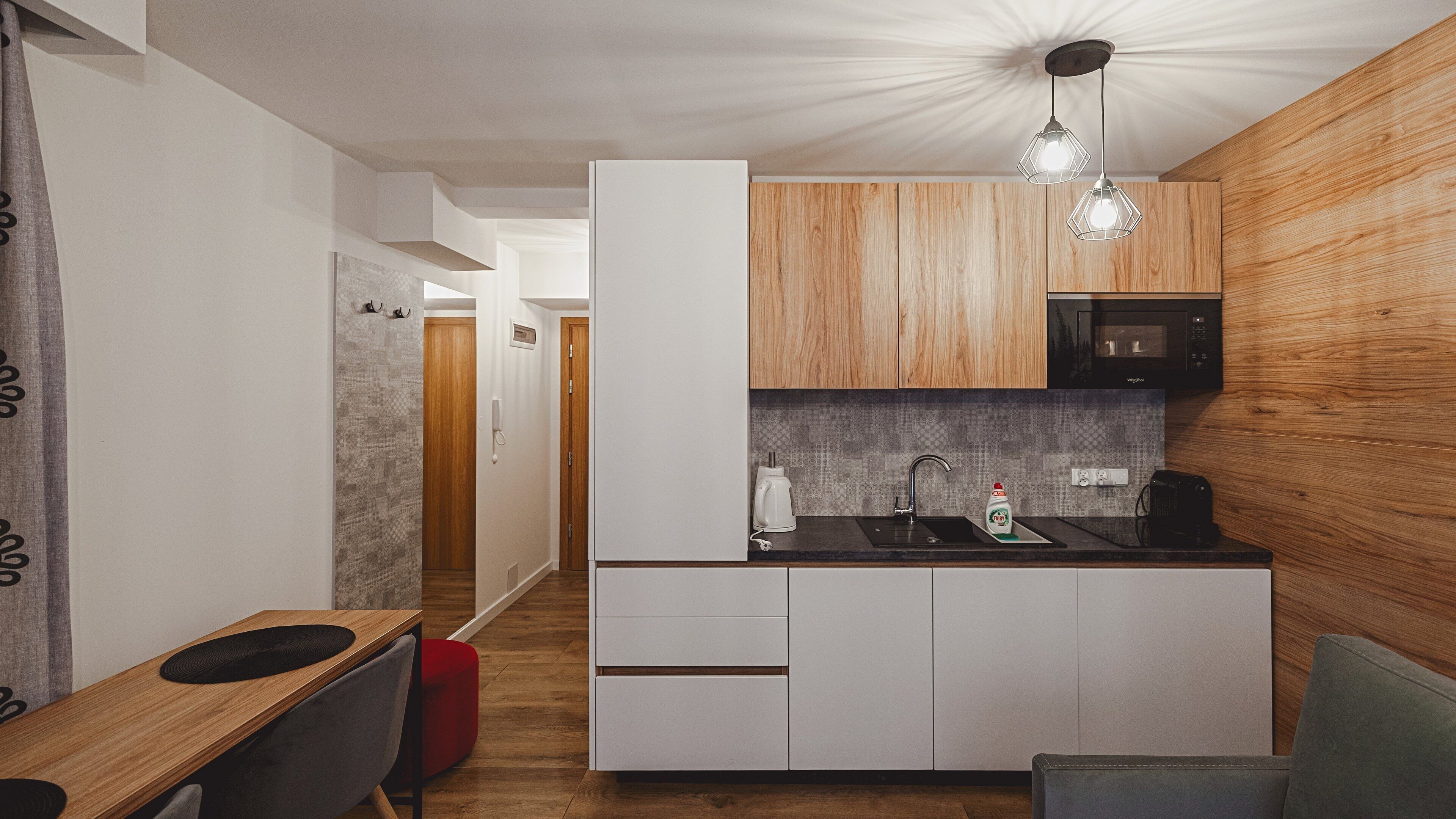 Une cuisine moderne avec des meubles en bois, un four à micro-ondes et un évier.