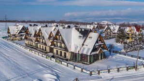 Una hilera de edificios de estilo chalet con tejados inclinados, probablemente parte de una estación de esquí.