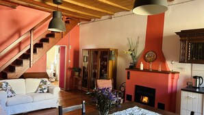 A cozy living room with a fireplace, wooden staircase, and a dining area. - Tango House (Zandobbio)