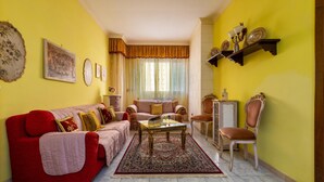 A living room with a red sofa, a coffee table, and a patterned rug. - 3283 Appartamento Garibaldi by Barbarhouse (Carmiano)