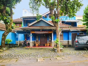 A building with a blue facade, a tiled roof, and a sign reading "Baleat Eendah".