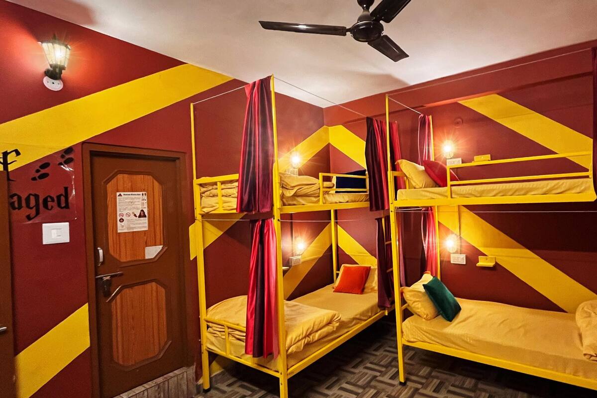 A room with bunk beds, a ceiling fan, and a door with a sign.
