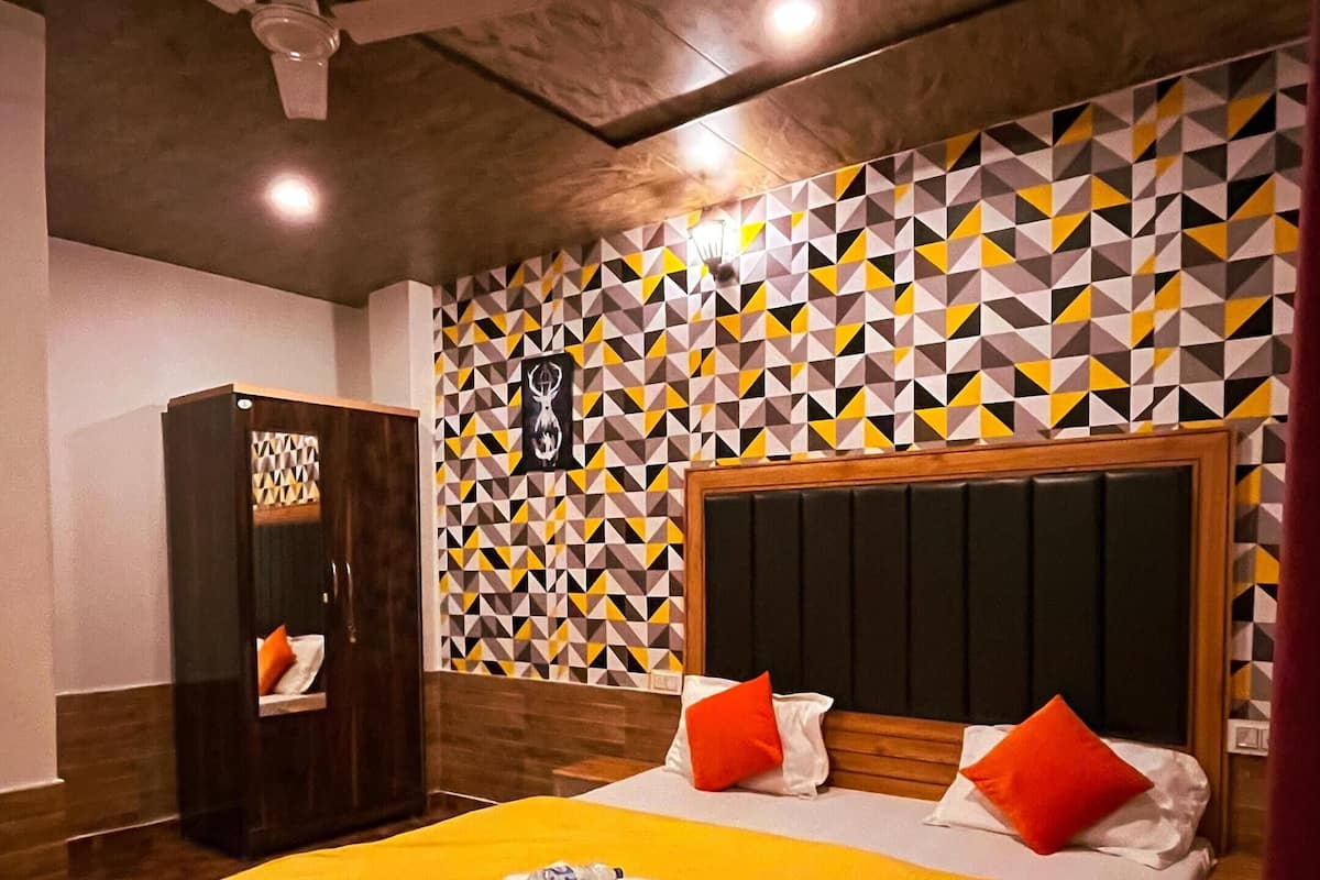 A room with a bed, a wardrobe, and a patterned wall.