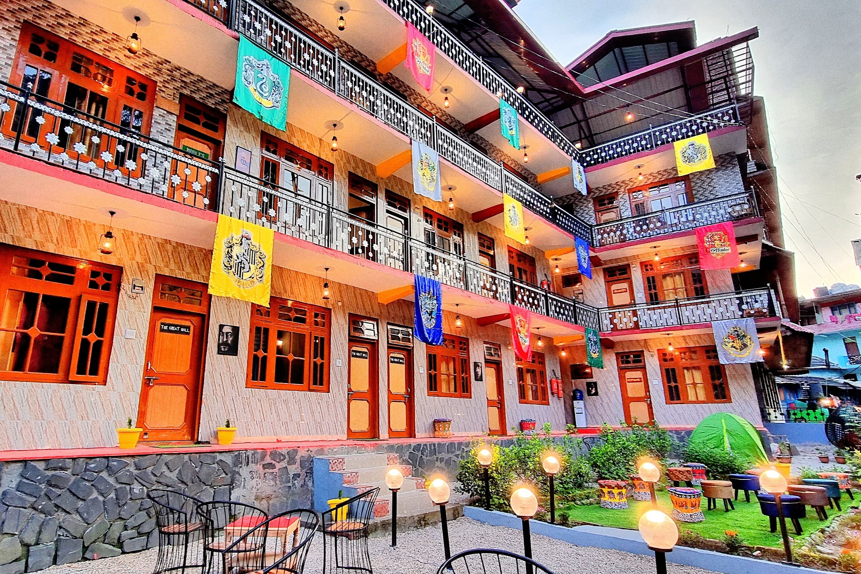 A multi-story hotel with balconies, outdoor seating, and flags.