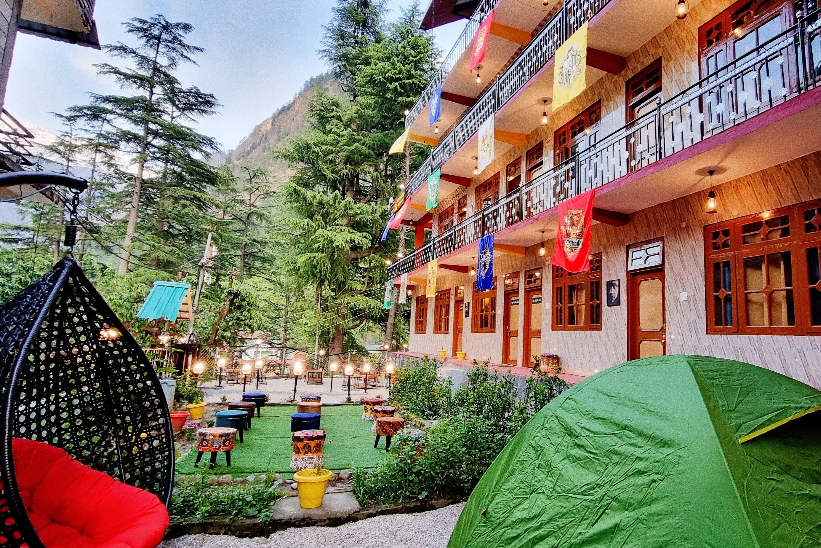 A hotel with a courtyard, outdoor seating, and a tent.