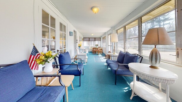 A sunlit interior with blue upholstered seating, a small table, and a lamp. - FT Away From Lake MI Beaches Golf Tennis Park Trails & More Dog Friendly New AC (New Buffalo)