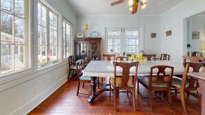 A dining room with a large table, wooden chairs, and a vintage cabinet. - FT Away From Lake MI Beaches Golf Tennis Park Trails & More Dog Friendly New AC (New Buffalo)