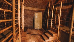 Ein Dachzimmer mit Holzbalken, einer Leiter und einer Tür.