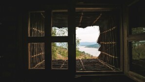 Ein Zimmer mit einem großen Fenster mit Blick auf einen See und Berge.