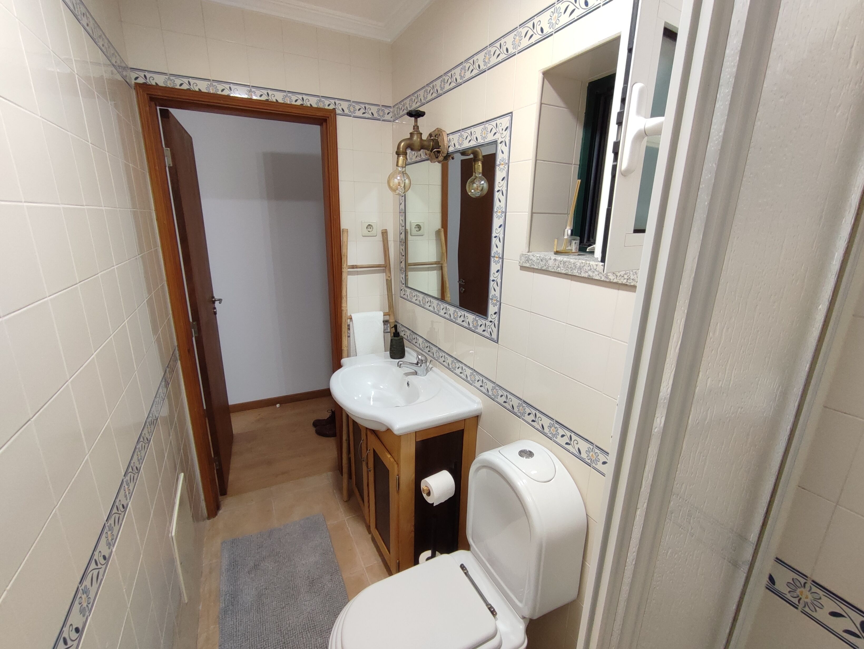 Une salle de bain avec un lavabo, des toilettes et un miroir.